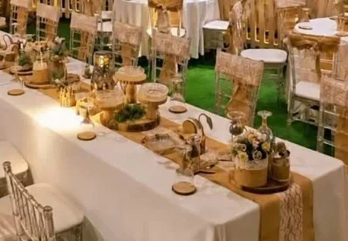 Close-up of a dressed table with wood-slice settings, candles and small flower arrangements